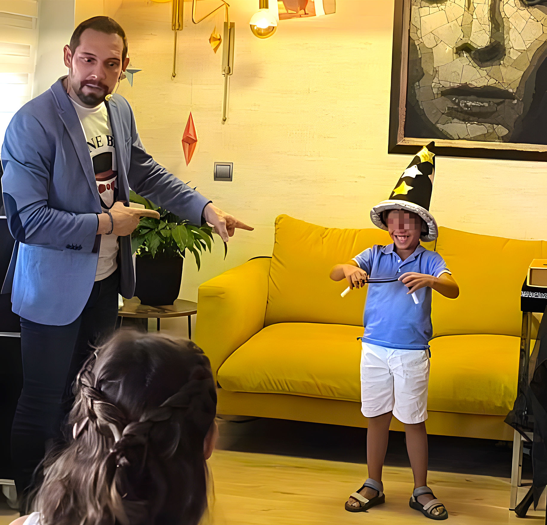 Mago para cumpleaños Madrid Mane Bau sorprendido y señalando a un niño que ha roto la varita y se ríe