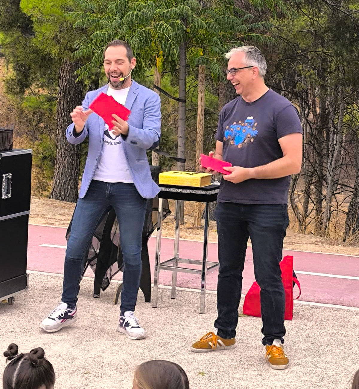 Mago para cumpleaños Madrid actuando en un parque y a su lado un espectador colaborando con el juego de magia