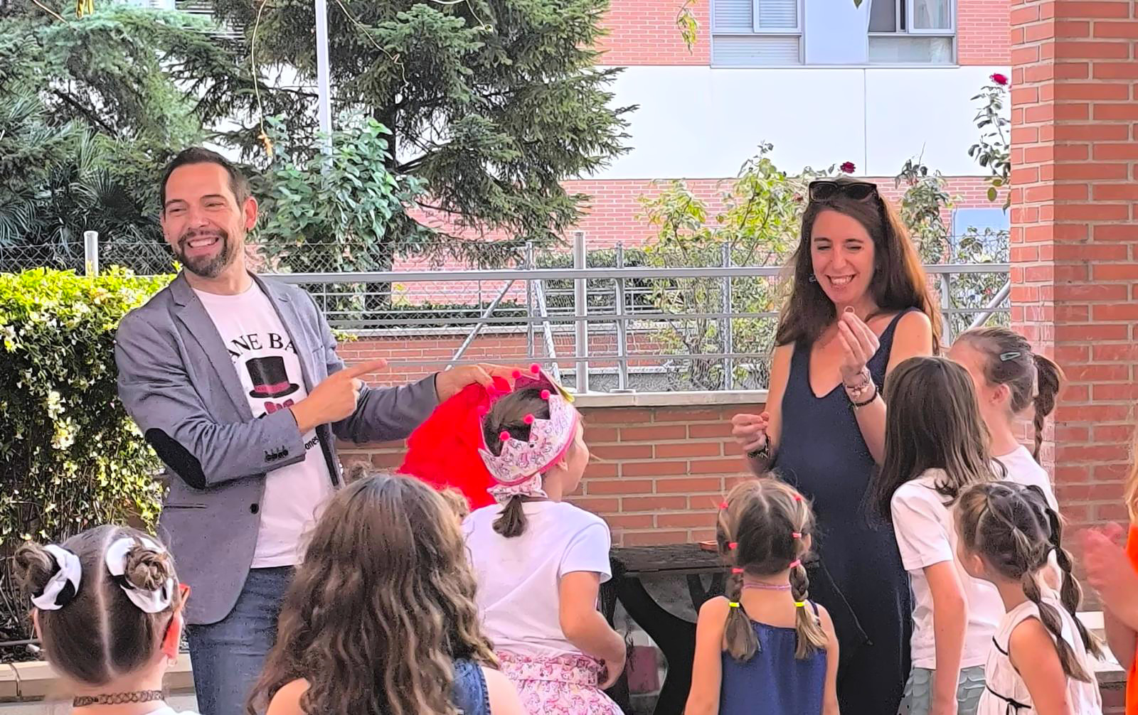 Mane Bau actuando como mago para cumpleaños Madrid señalando a una madre mientras niños se levantan